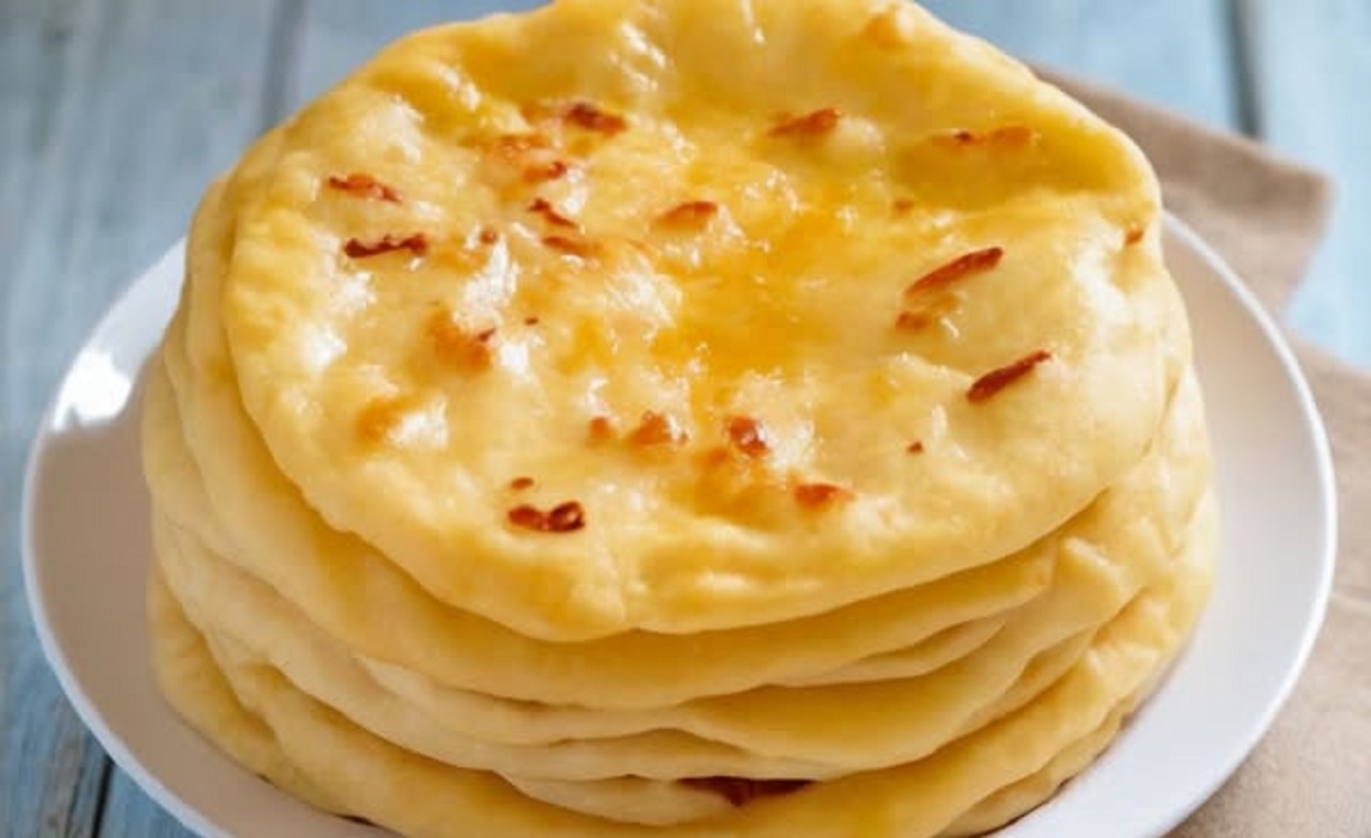 Skillet bread cooking on stovetop with golden crust