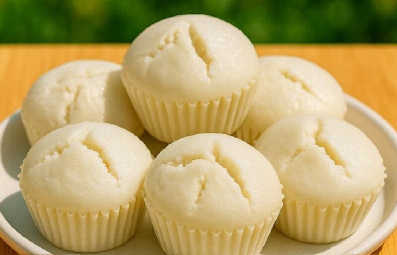 Bowl of puto batter with whisk and plate of fluffy steamed rice cakes